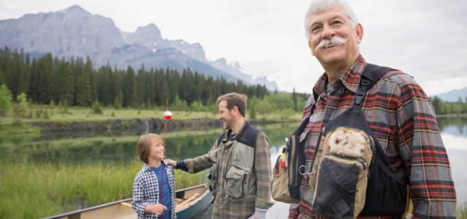 Three men by river fly fishing